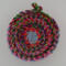 This view is looking down into the fabric rope basket. It shows the variety of all the scraps used to make the rope which made the basket.